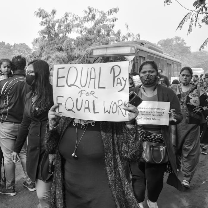 services-01 A group of people protesting for equal pay holding placards in a social justice demonstration.
