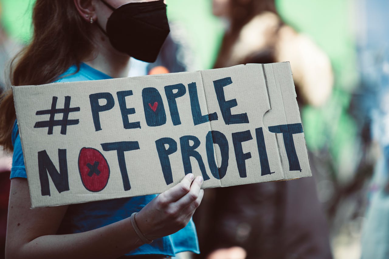 heros-img Street protest highlighting social justice with a People Not Profit sign.