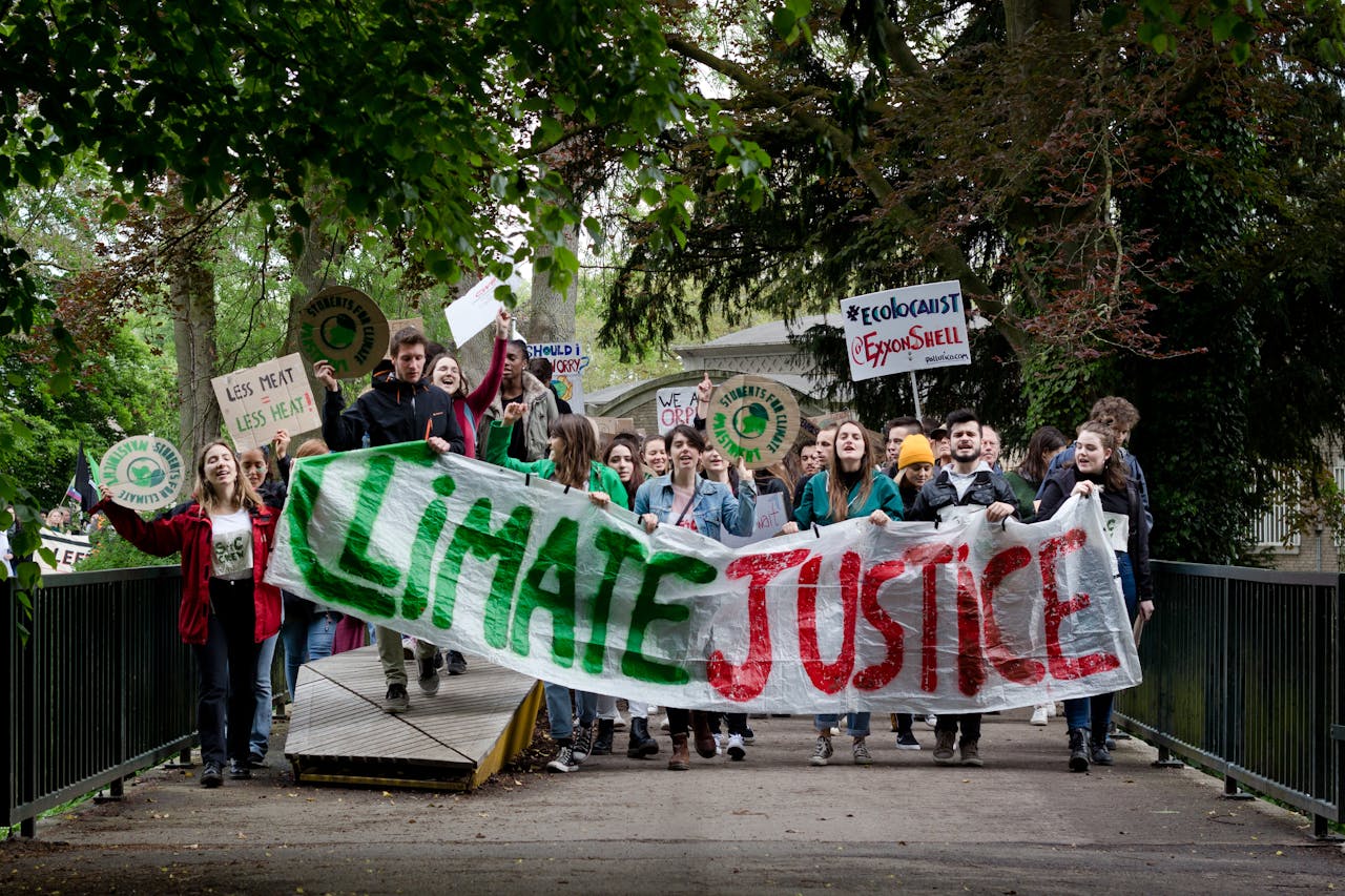 who-we-are Group of activists marching for climate justice in Maastricht with banners and signs.