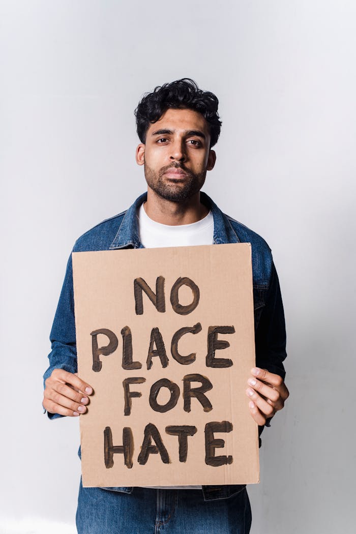 our-story A man holding a 'No Place for Hate' sign advocating against hate and discrimination.
